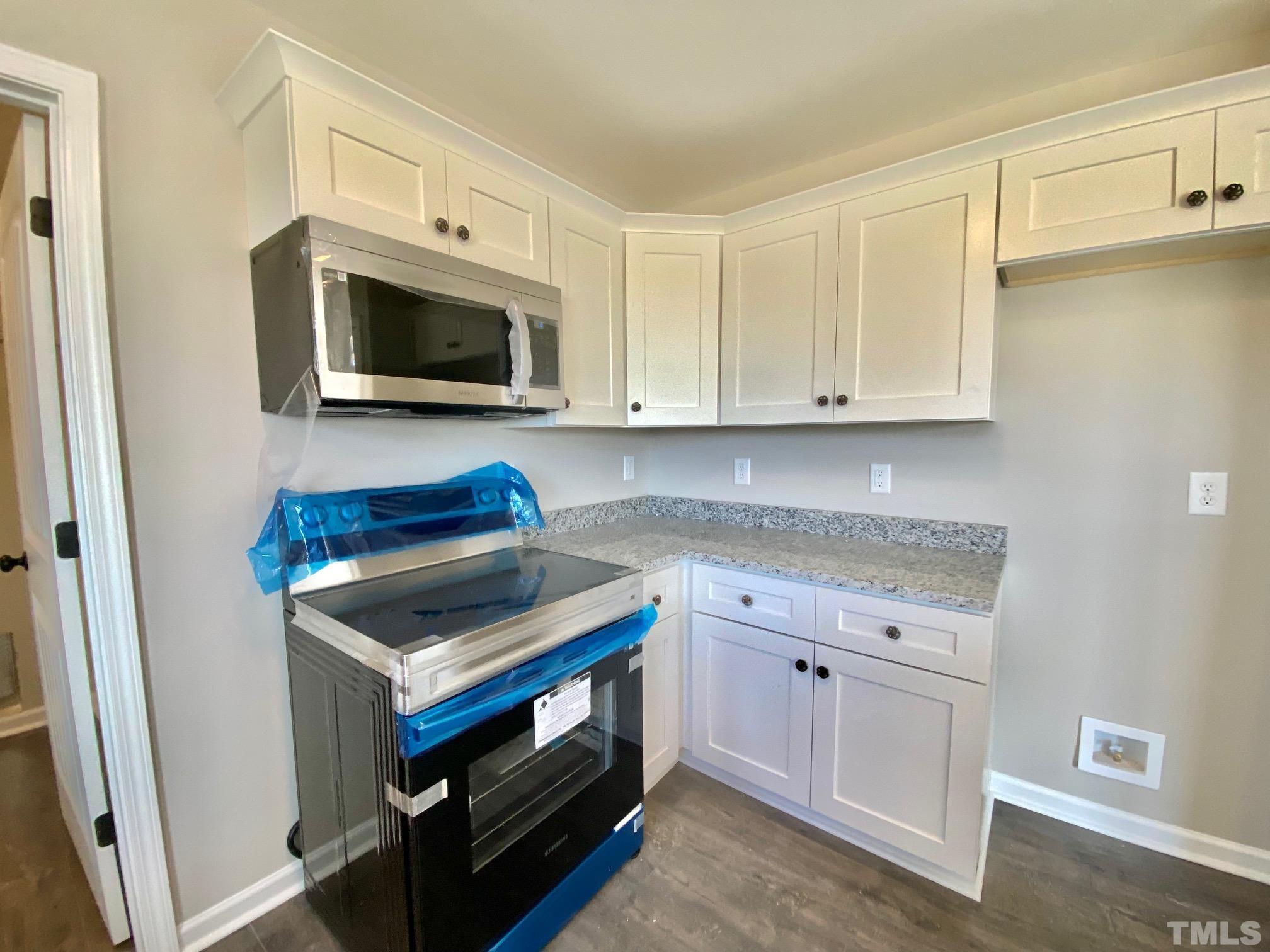 136 Mamie Road Benson, NC 27504 - Photo 16 of 32 a kitchen with stainless steel appliances granite countertop a stove microwave and sink