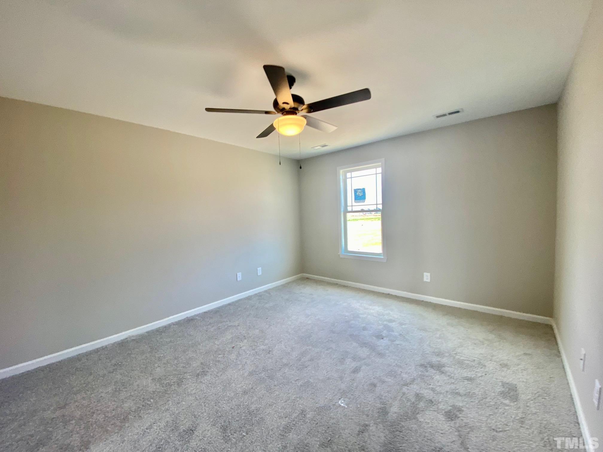 136 Mamie Road Benson, NC 27504 - Photo 18 of 32 an empty room with a window and a fan