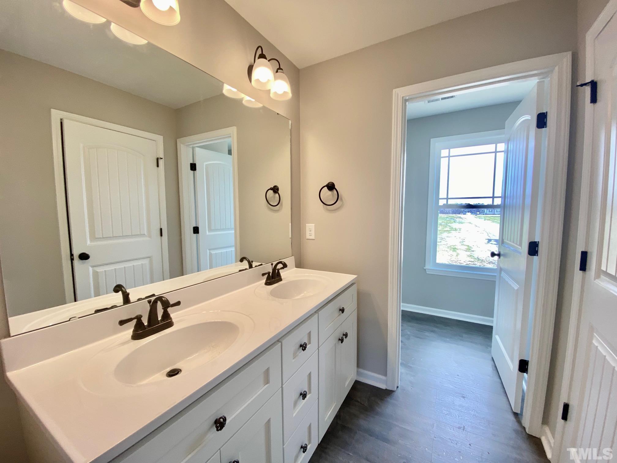 136 Mamie Road Benson, NC 27504 - Photo 21 of 32 a spacious bathroom with a double vanity sink and mirror
