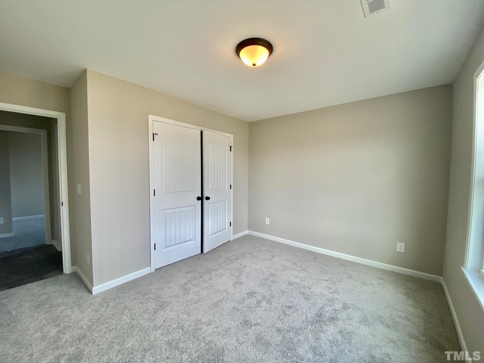 136 Mamie Road Benson, NC 27504 - Photo 30 of 32 an empty room with windows and closet