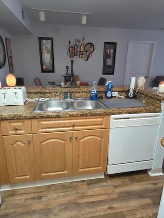 a kitchen with granite countertop a sink cabinets and stainless steel appliances