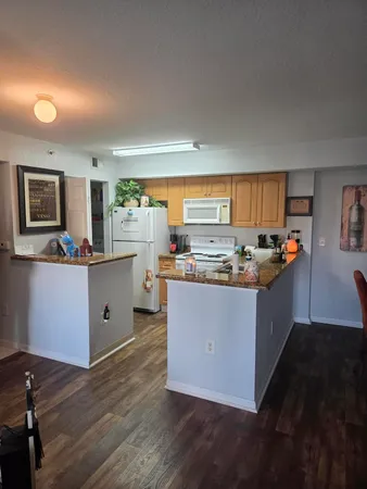 a kitchen with stainless steel appliances granite countertop a stove a sink dishwasher and a microwave oven with white cabinets