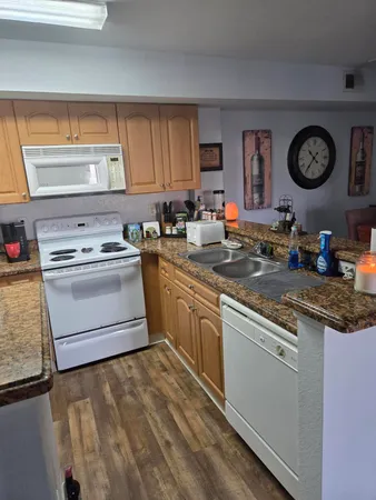 a kitchen with stainless steel appliances granite countertop a stove a sink and a microwave