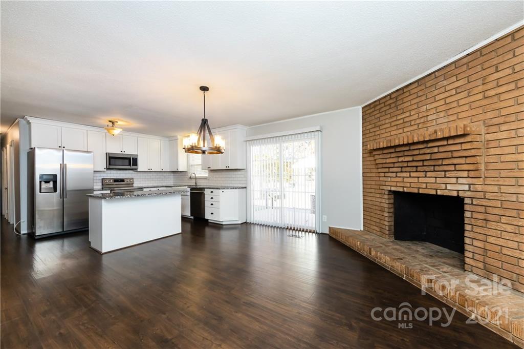 4003 Beaty Road Gastonia, NC 28056 - Photo 14 of 41 a kitchen with stainless steel appliances kitchen island wooden cabinets and a fireplace