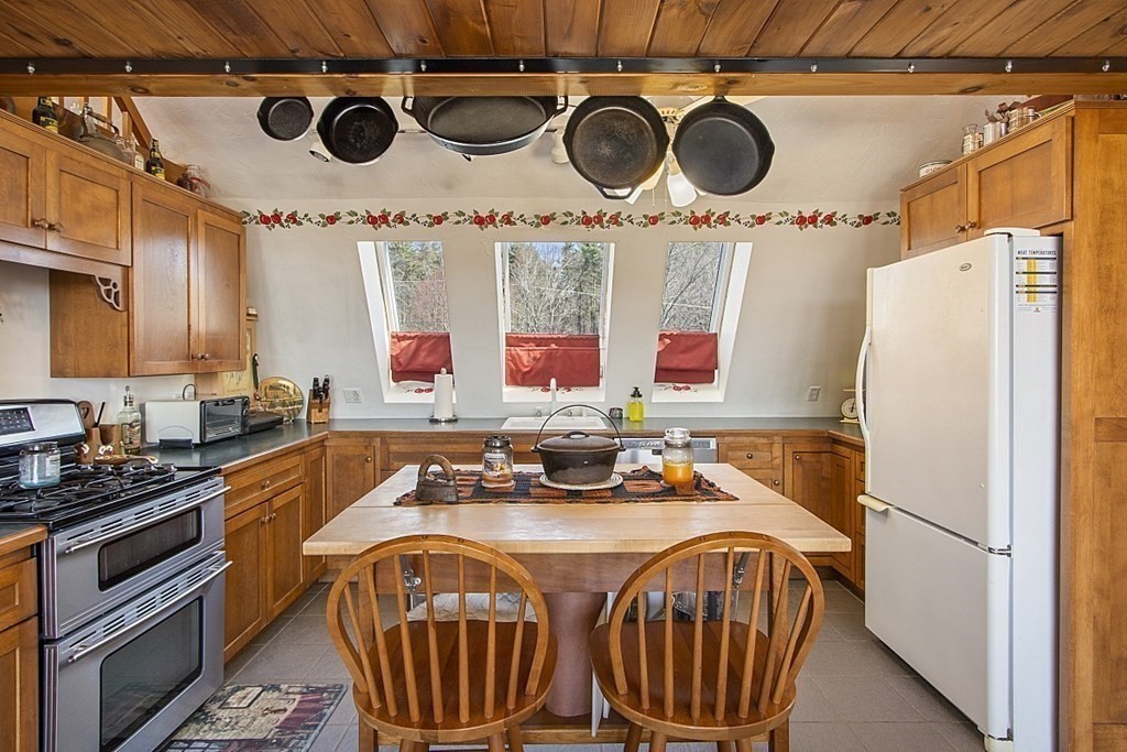 178 Wallace Hill Road Townsend, MA 01469 - Photo 6 of 42 a kitchen with stainless steel appliances a stove a microwave and a refrigerator
