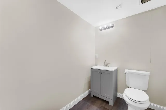 a bathroom with a toilet a sink and mirror