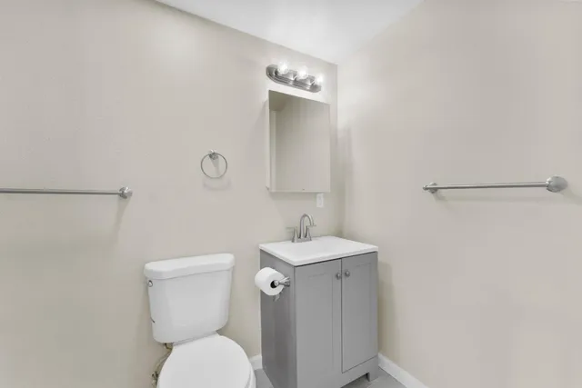a bathroom with a toilet a sink and mirror