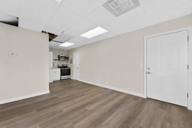 a view of empty room with wooden floor