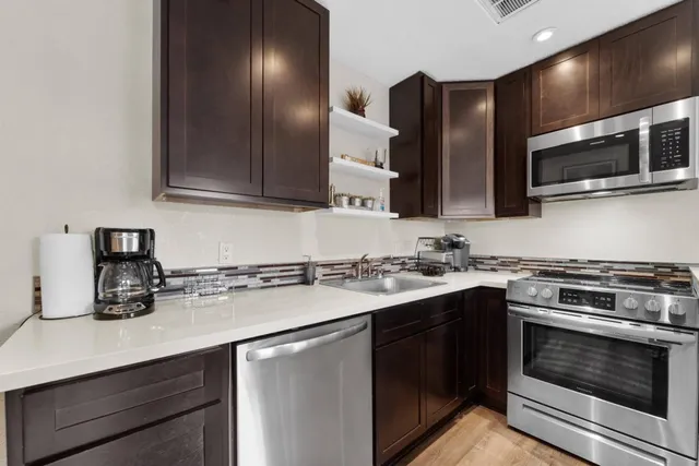 a kitchen with stainless steel appliances a sink stove and microwave