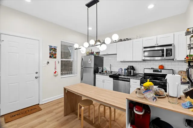a kitchen that has a lot of cabinets and stainless steel appliances