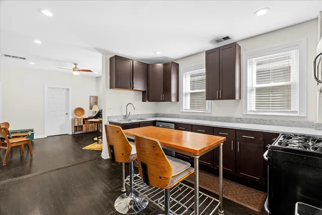 a kitchen with a table chairs sink and cabinets