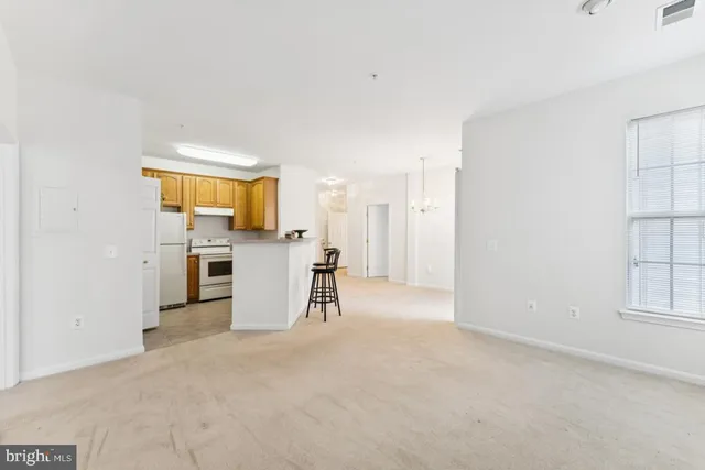 an empty room with a kitchen view and a window