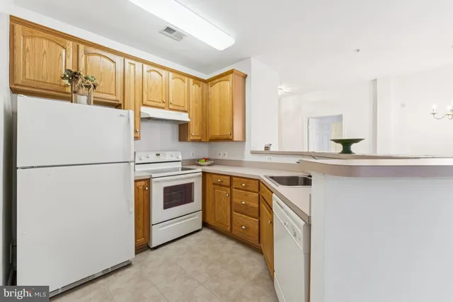 a kitchen with stainless steel appliances granite countertop a refrigerator a stove a sink and a microwave