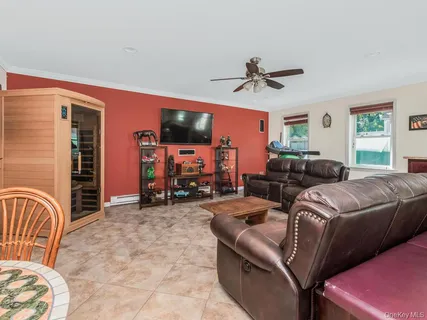 a living room with furniture a ceiling fan and a window