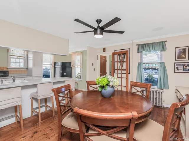 a dining room with furniture a potted plant and wooden floor