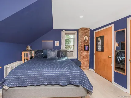 a bedroom with a large bed and a wooden floor