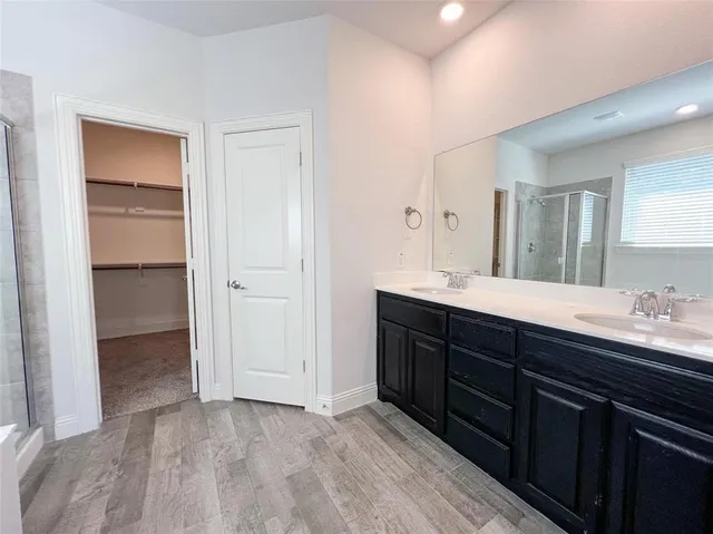 a spacious bathroom with a double vanity sink and a mirror