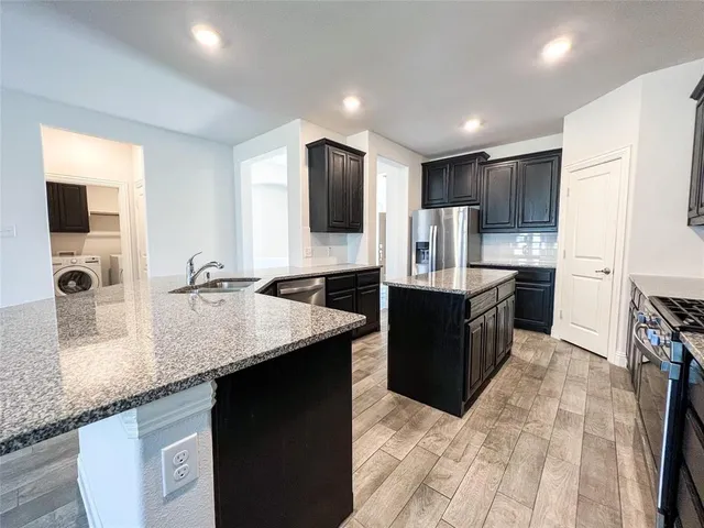 a kitchen with stainless steel appliances granite countertop a sink counter space cabinets and a large mirror