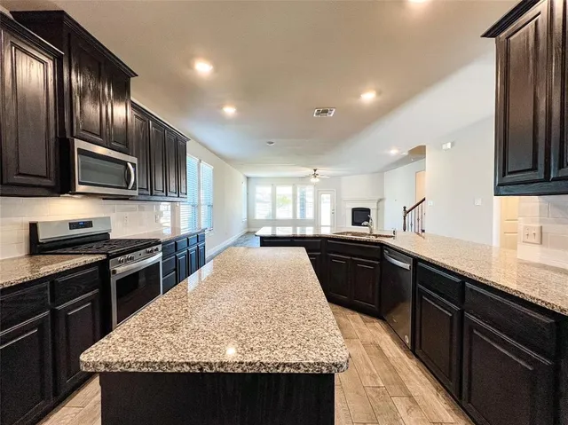a kitchen with granite countertop stainless steel appliances and wooden cabinets