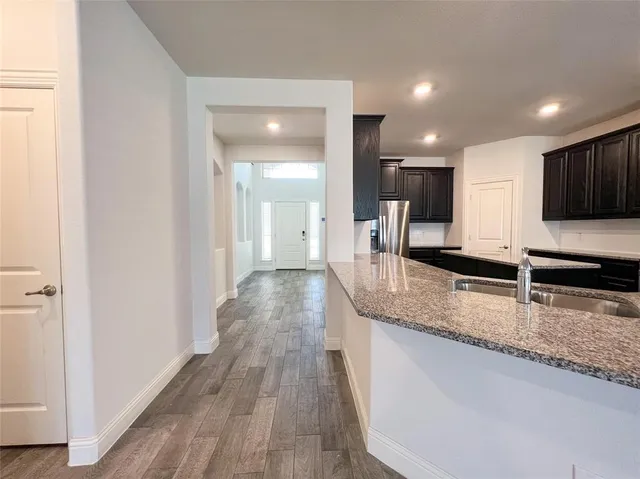 a view of a kitchen with kitchen island a sink stainless steel appliances and cabinets