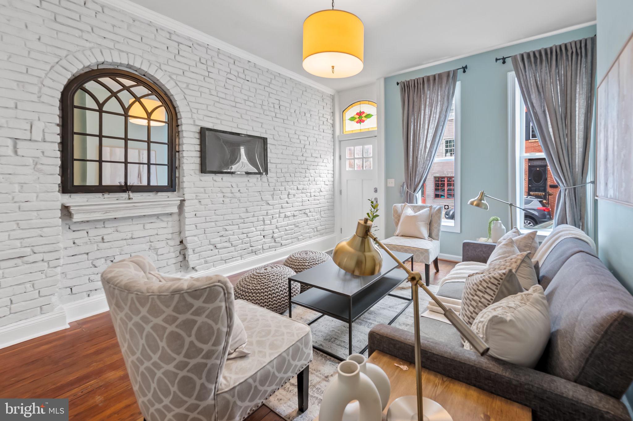 1045 Riverside Avenue Baltimore, MD 21230 - Photo 1 of 32 a living room with furniture a fireplace and a floor to ceiling window