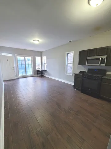 a view of a livingroom with wooden floor and furniture