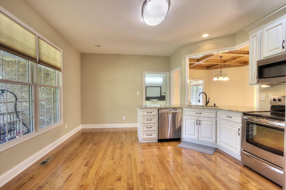 1400 Grimes Road Loudon, TN 37774 - Photo 18 of 32 a kitchen with stainless steel appliances granite countertop a stove a sink dishwasher and a microwave oven with wooden floor