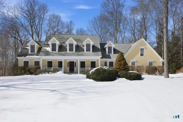 a view of a white house with a yard covered in snow