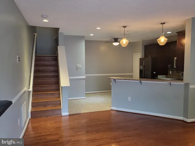 a view of a livingroom with an entryway and wooden floor