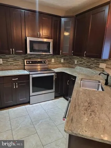 a kitchen with a sink stove and microwave
