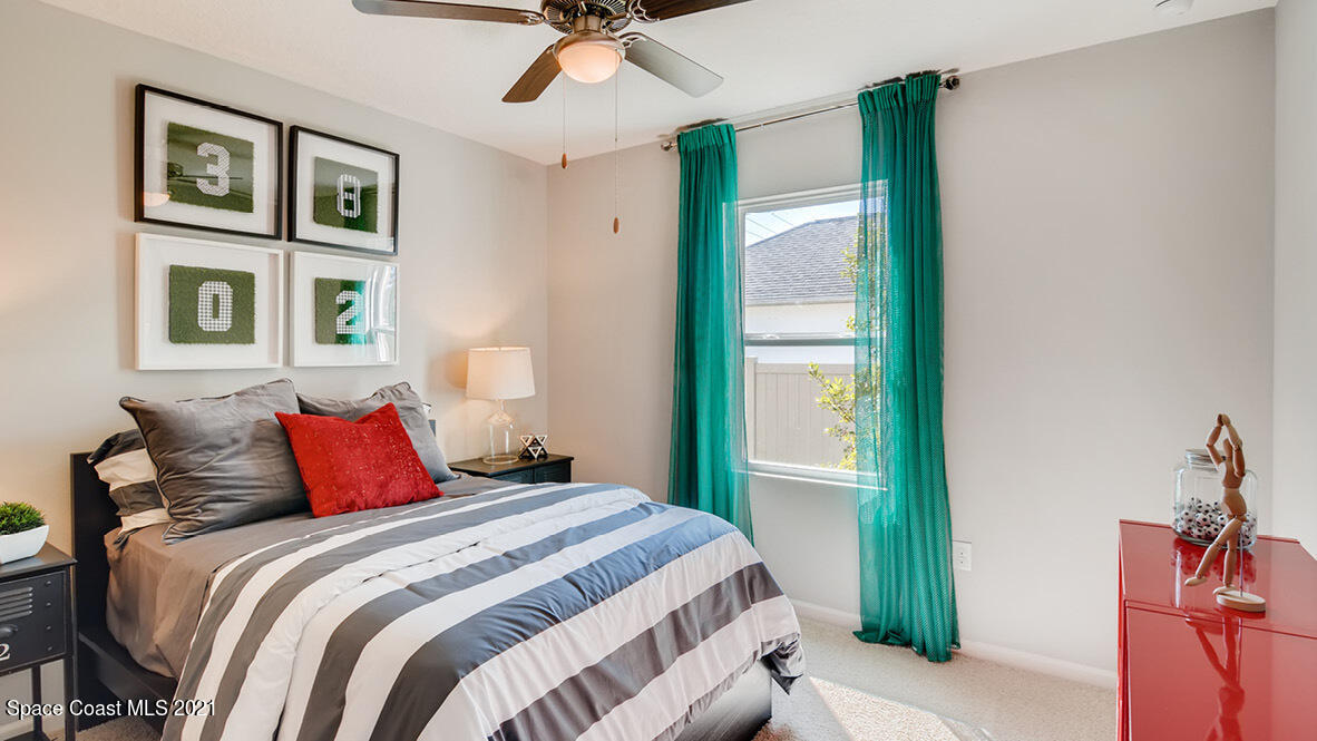 519 Old Country Rd S East Palm Bay, FL 32909 - Photo 9 of 29 a bedroom with a large bed and a chandelier