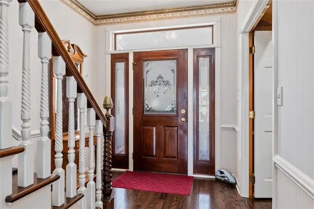 a view of a hallway with wooden floor and stairs