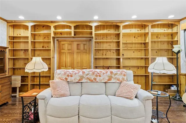 a living room with a couch and dresser with wooden floor