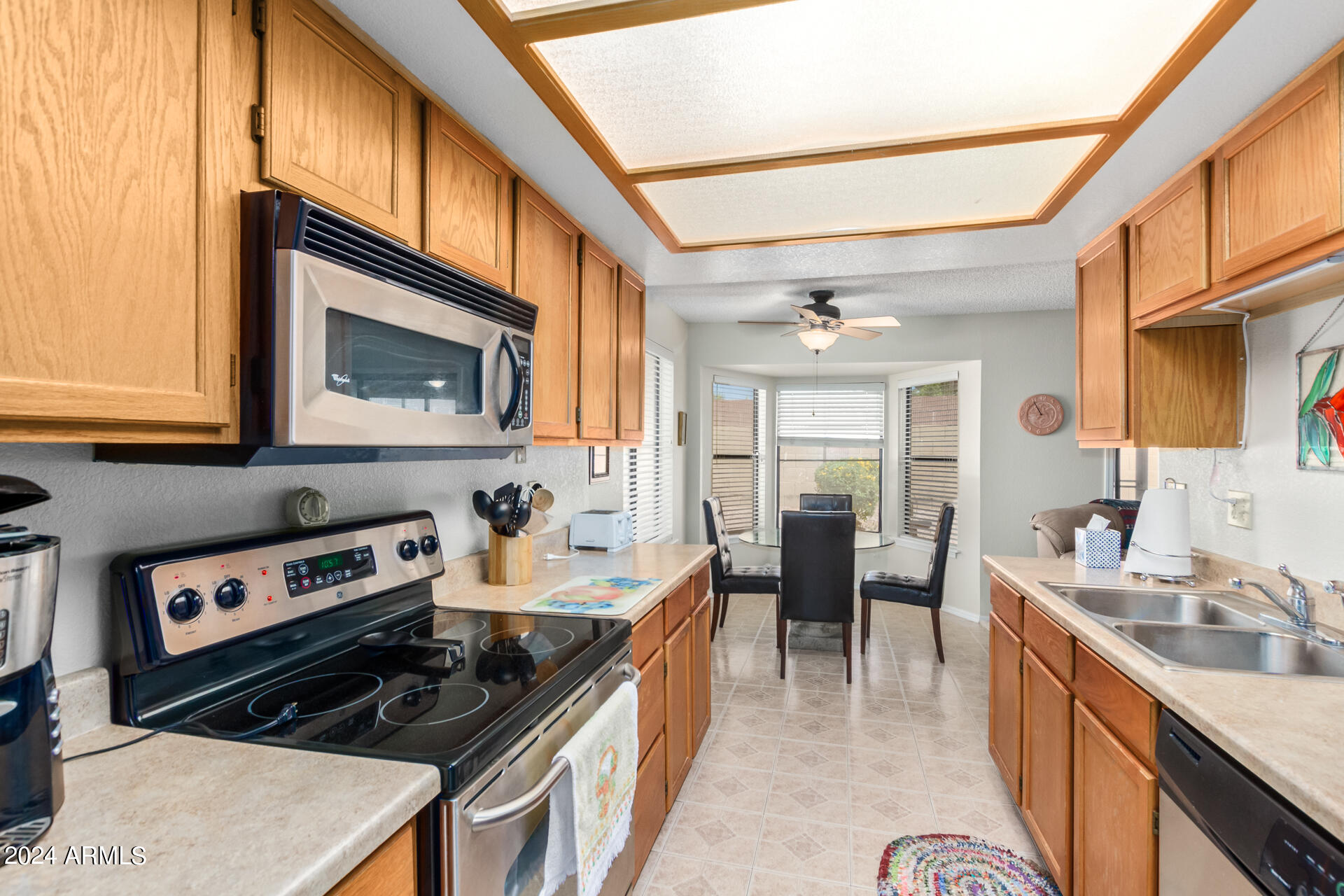 1021 South Greenfield Road, Unit 1058 Mesa, AZ 85206 - Photo 3 of 14 a kitchen with stainless steel appliances granite countertop a stove a sink and a microwave