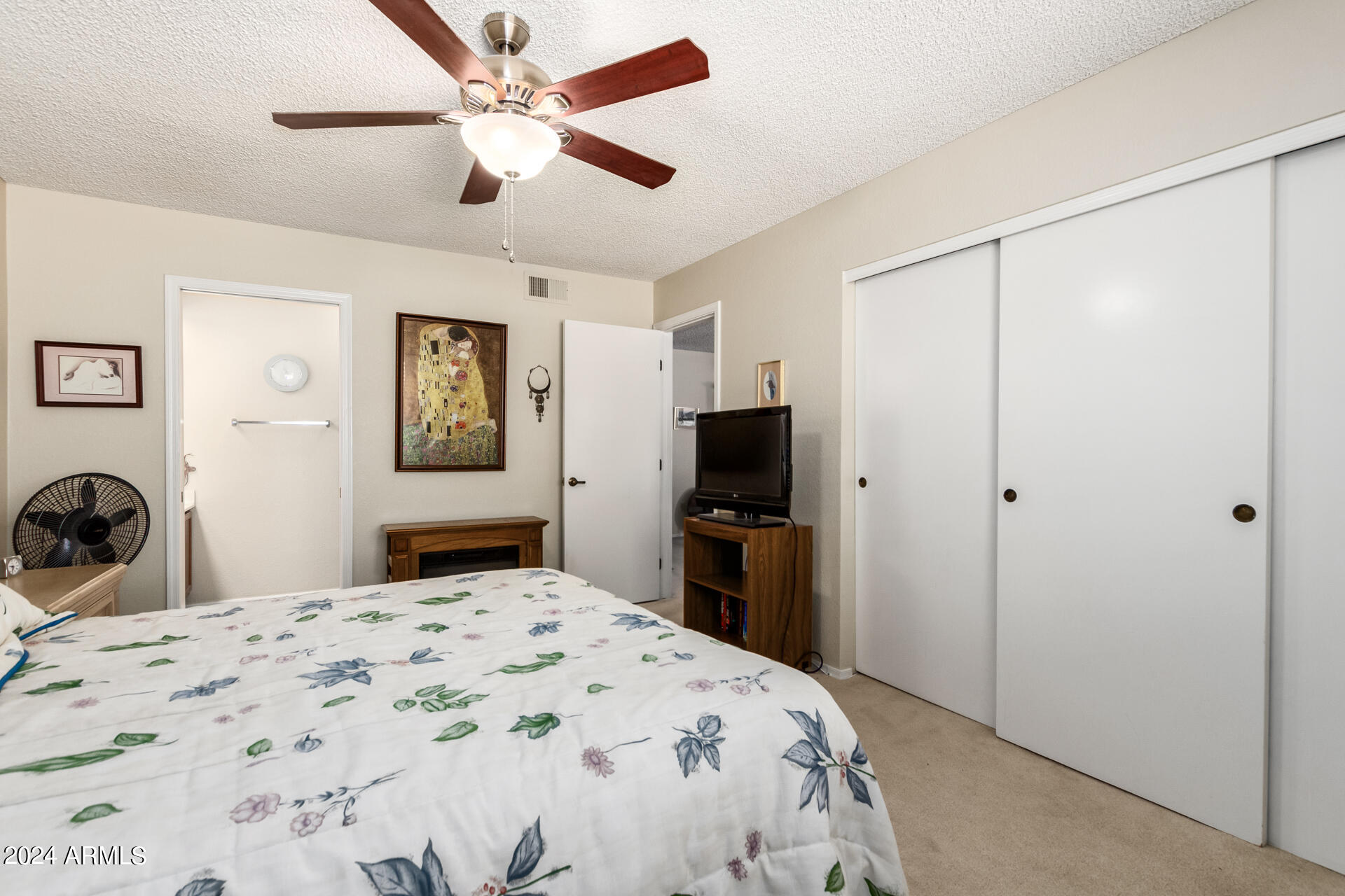 1021 South Greenfield Road, Unit 1058 Mesa, AZ 85206 - Photo 9 of 14 a bedroom with a bed and a flat tv screen on dresser