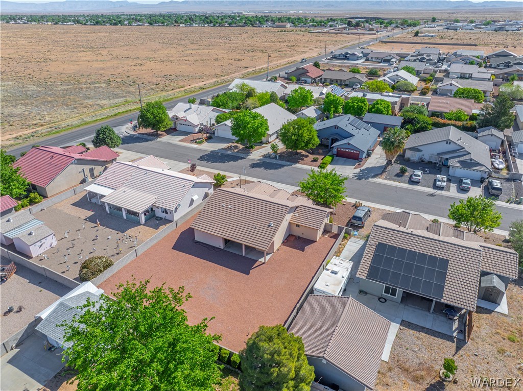 3973 Prairie View Drive Kingman, AZ 86409 - Photo 8 of 34 Aerial view of the property and surrounding neighborhood, featuring a large, unpaved yard, a covered patio, and a utility shed