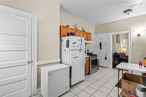 a kitchen with a refrigerator and white cabinets