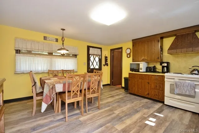a kitchen with stainless steel appliances kitchen island granite countertop a table chairs sink and cabinets