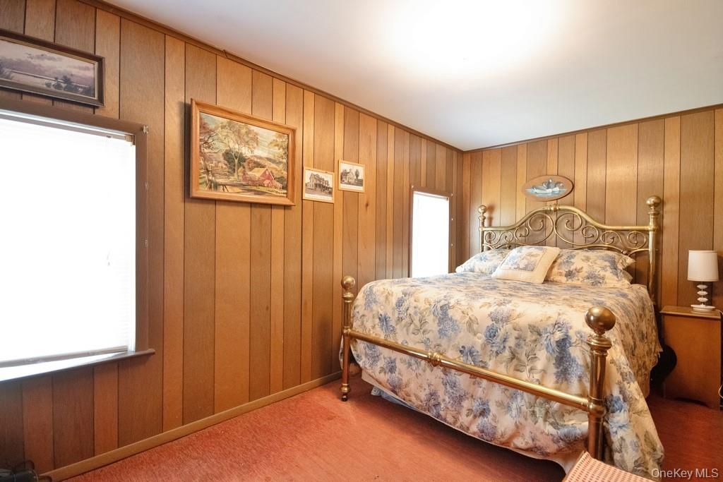 169 Mitchell Pond E Road Cochecton, NY 12726 - Photo 17 of 33 a bed sitting in a spacious bedroom next to a window