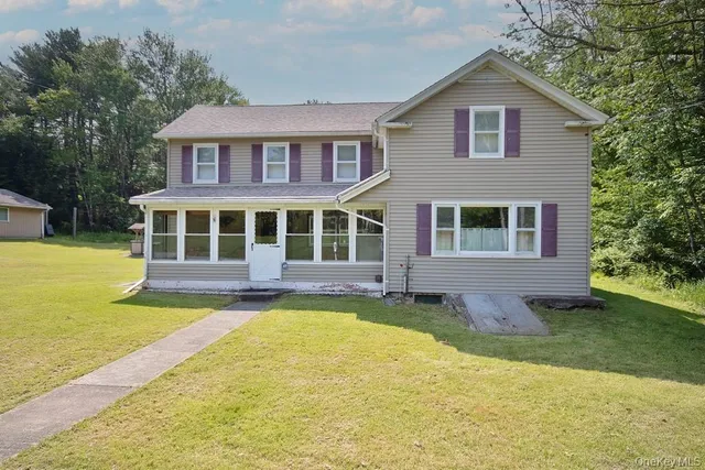 a front view of a house with yard and green space