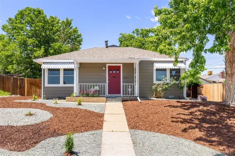 a front view of a house with a yard and potted plants