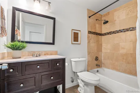 a bathroom with a granite countertop toilet sink and mirror