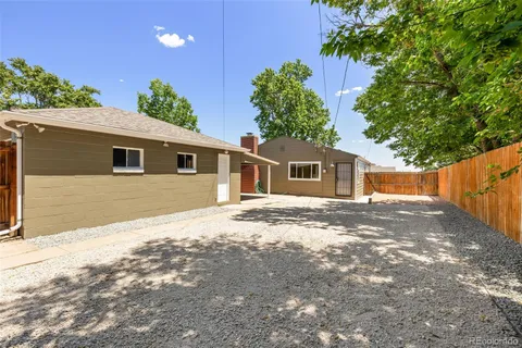 a front view of house with yard and trees in the background