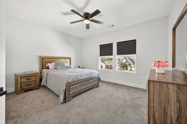 a bedroom with a bed and a flat tv screen on dresser