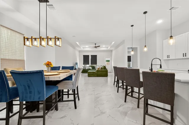 a dining room with furniture a chandelier and wooden floor