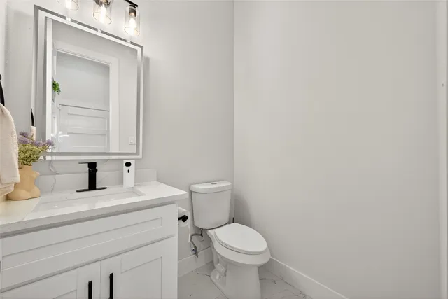 a bathroom with a toilet a sink and mirror