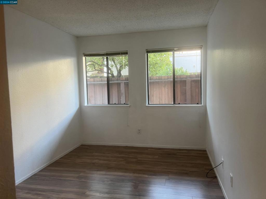 5075 Valley Crest Drive Concord, CA 94521 - Photo 13 of 20 a view of an empty room with wooden floor and a window