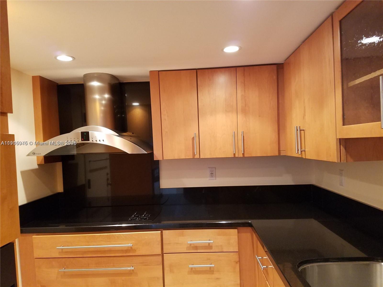 2333 Brickell Avenue, Unit 2215 Miami, FL 33129 - Photo 2 of 27 a kitchen with kitchen island granite countertop a sink and a stove top oven