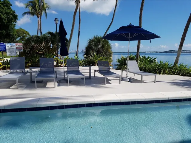 a view of a patio with chairs under an umbrella