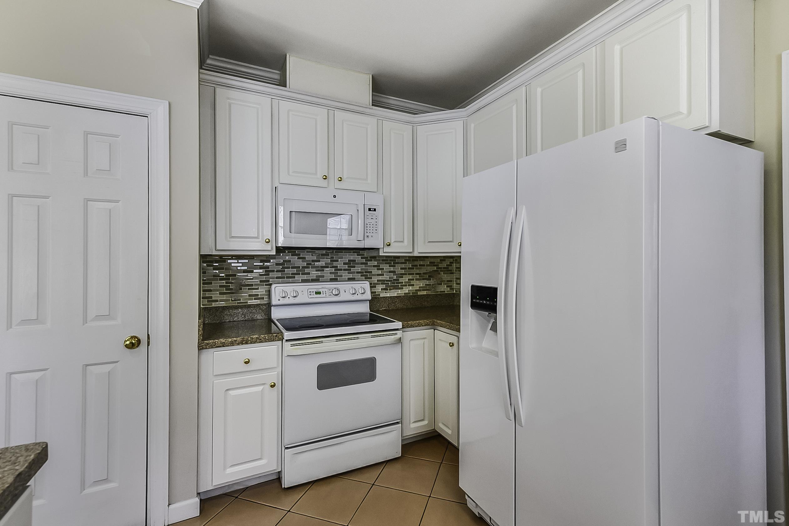 7929 Milltrace Run Raleigh, NC 27615 - Photo 14 of 36 a white refrigerator freezer sitting inside of a kitchen